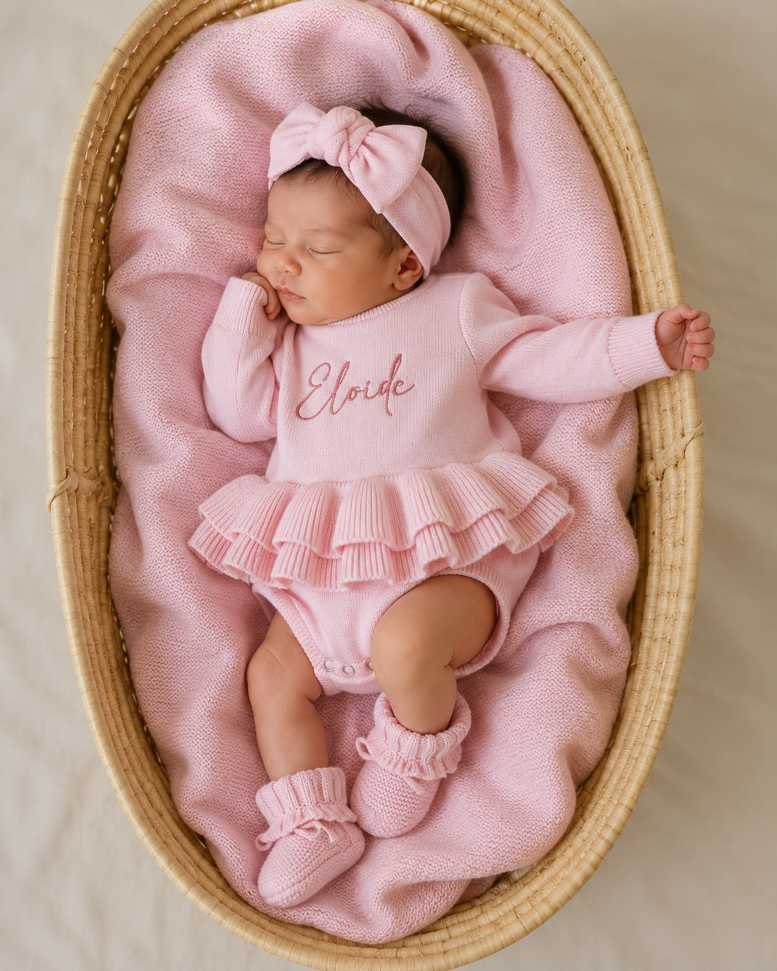 Side angle view of newborn wearing personalized petal pink Ballerina romper with ruffle booties