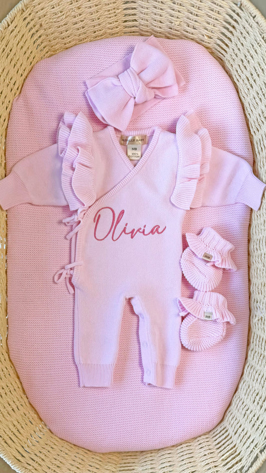 Personalized petal pink Butterfly long romper set displayed in a woven bassinet with matching bow and ruffle booties.