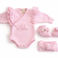Three-piece personalized petal pink Butterfly romper set with matching bow and booties on white background