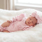 Newborn wearing personalized petal pink Butterfly romper with bow and booties on soft white blanket
