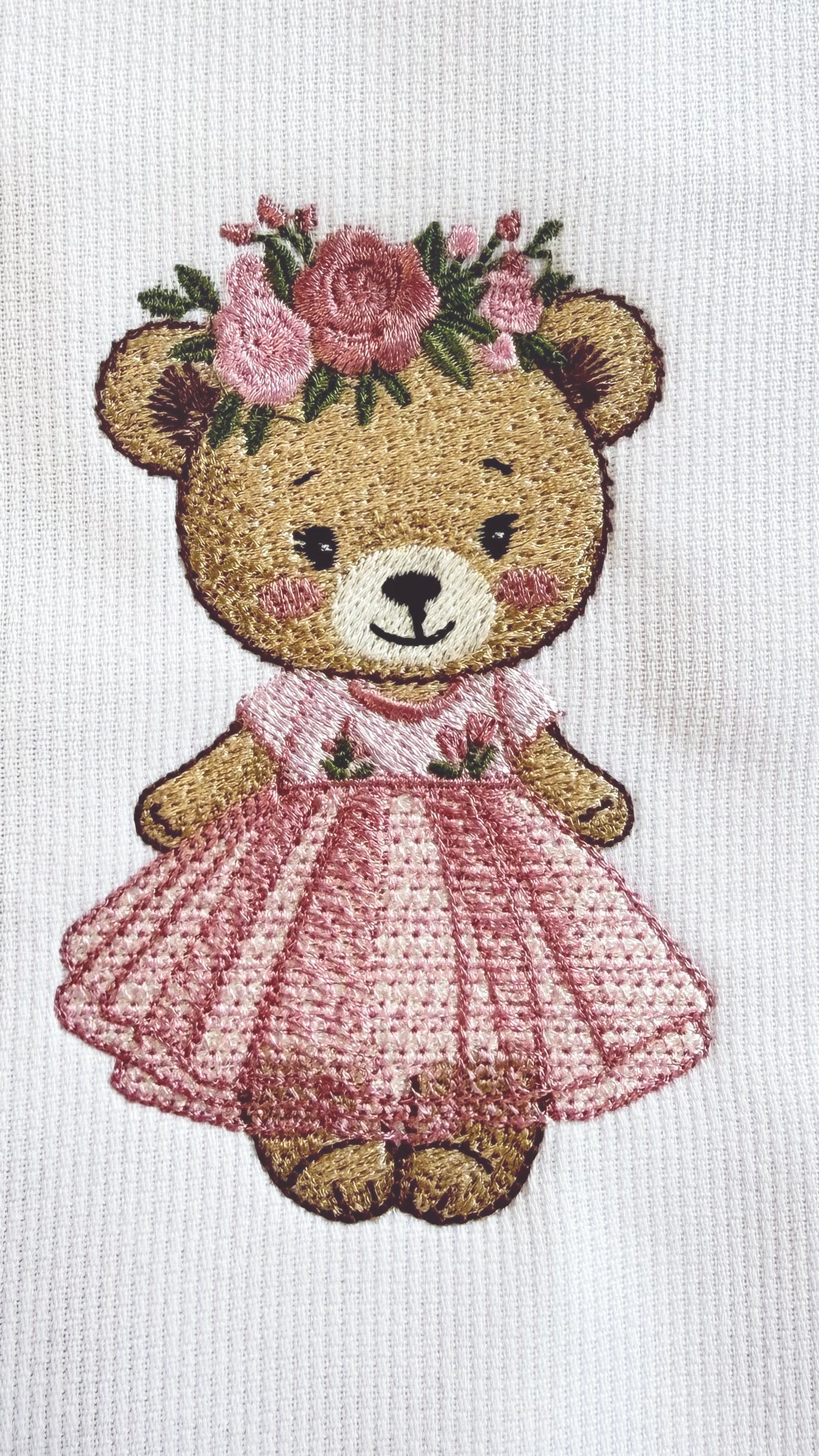 Close-up of embroidered monogram on personalized pink newborn bow sash