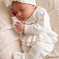 Sleeping newborn in the personalized Warm White Ballerina long romper and matching oversized bow.
