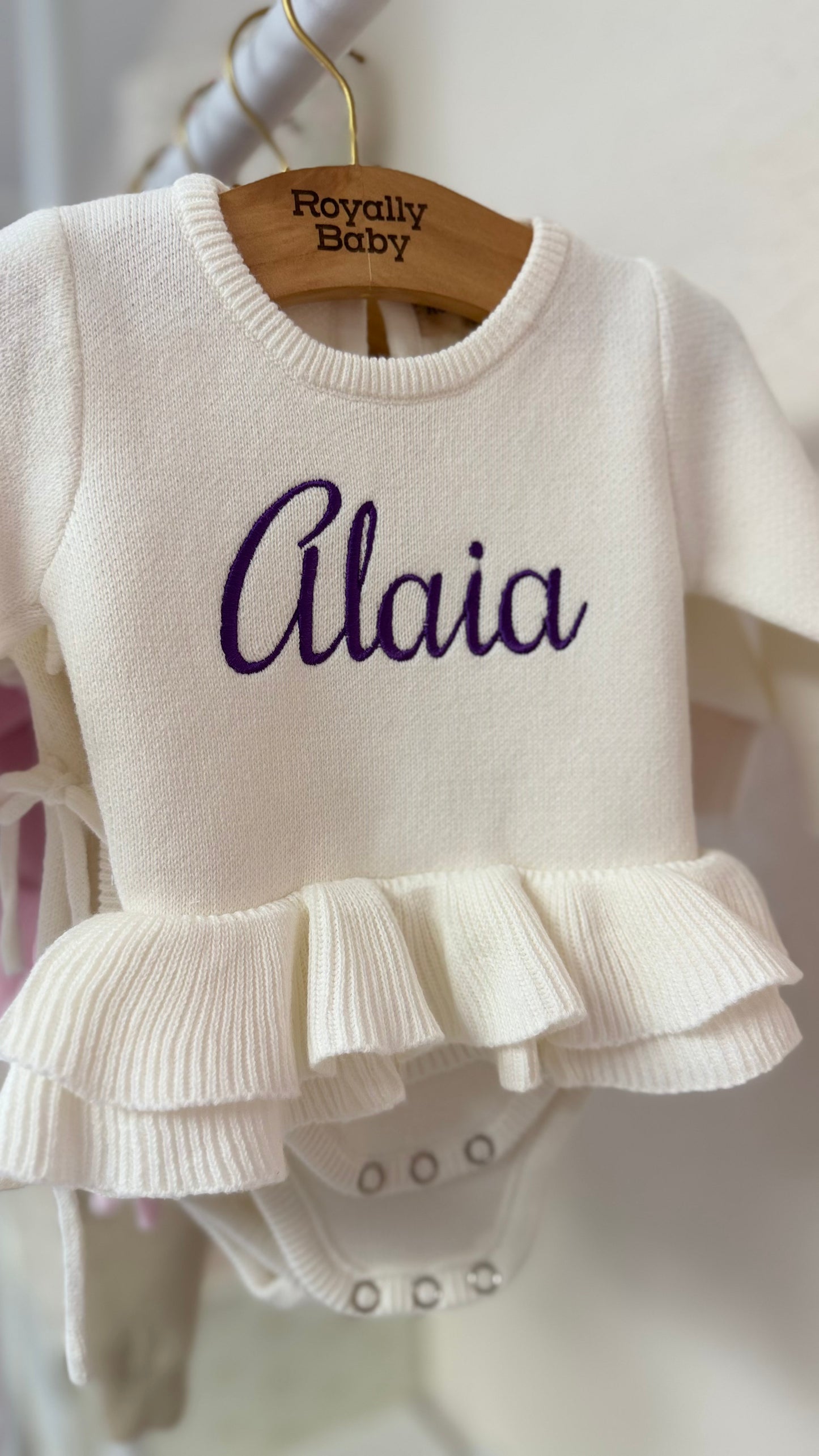 Newborn wearing personalized Warm White Ballerina romper with matching bow and booties