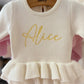 Newborn wearing personalized Warm White Ballerina romper, close detail