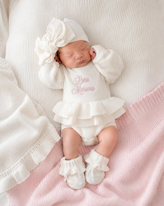 Newborn wearing personalized warm white Ballerina romper, short style, with embroidered name and matching bow and booties