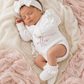 Newborn wearing personalized warm white Butterfly romper with bow and booties, close angle