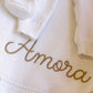 Personalized Warm White ruffle knit blanket embroidered with Amora in golden tan thread