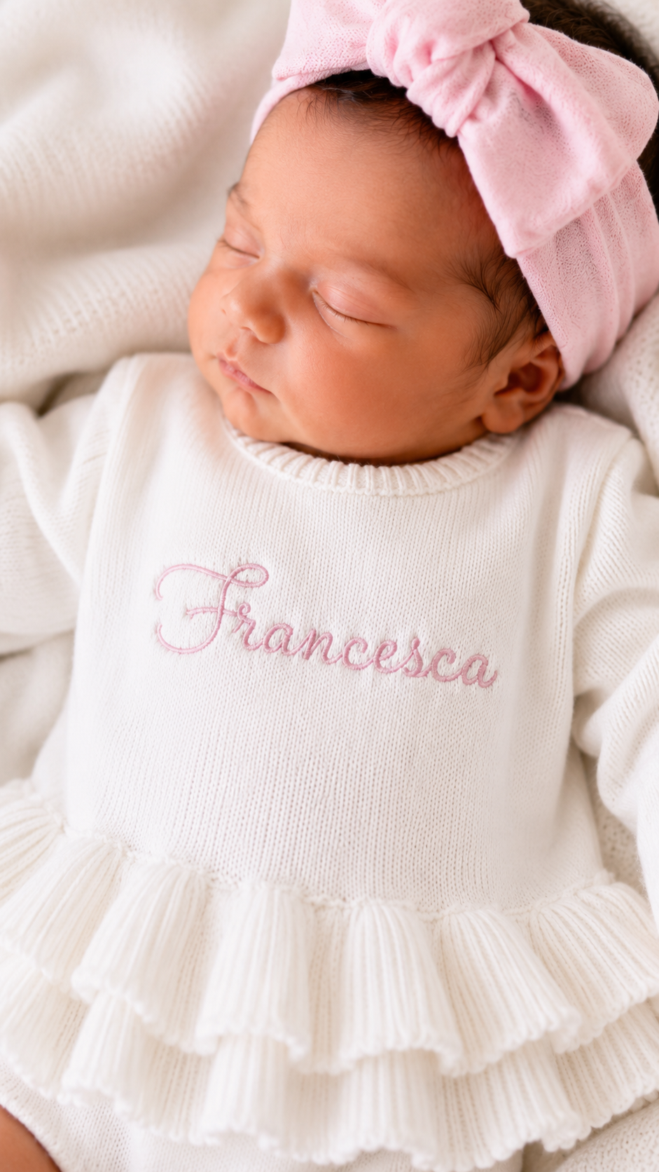 Newborn wearing personalized white and pink Ballerina romper with matching bow, close angle