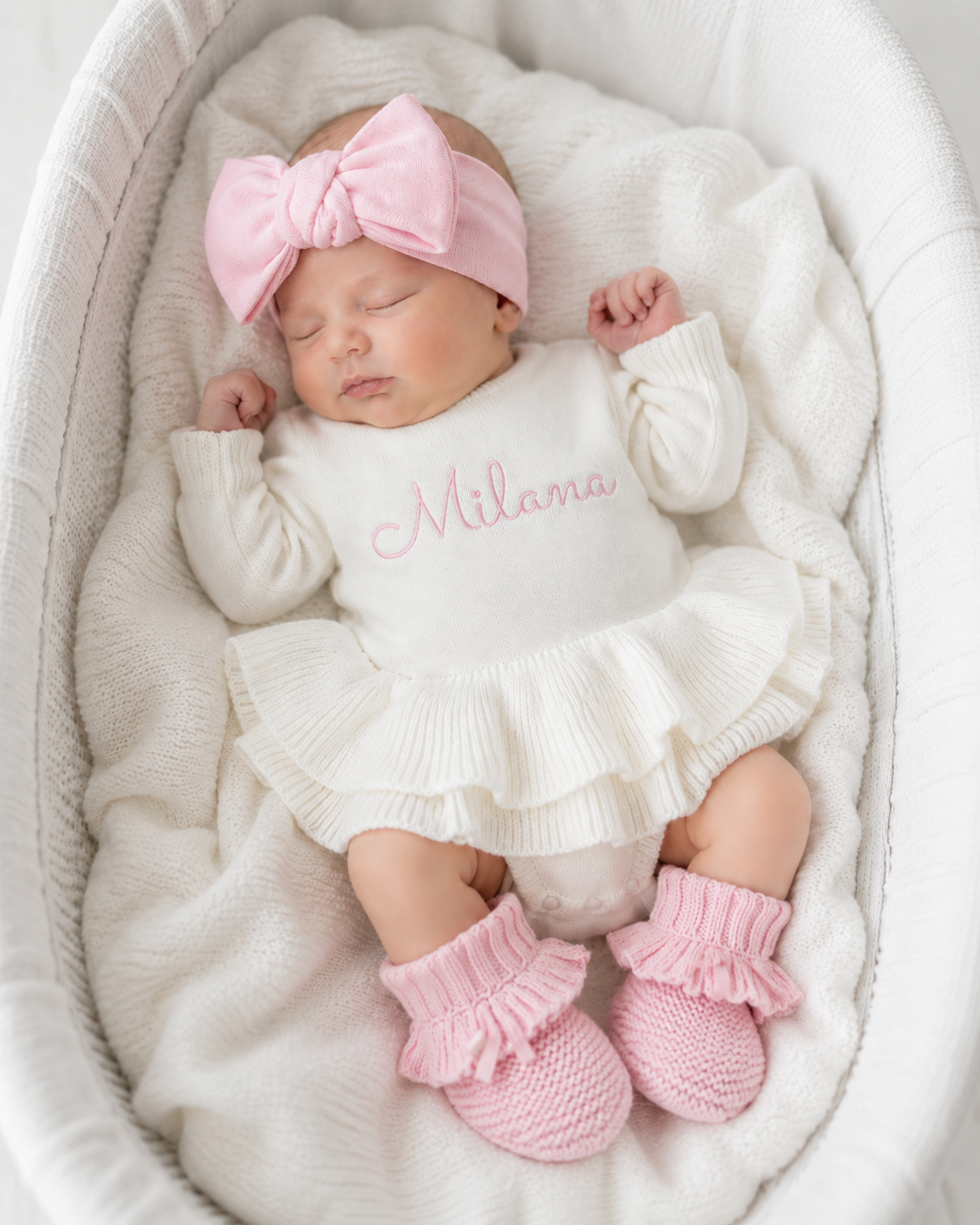 Newborn wearing personalized white and pink Ballerina romper, short style, with embroidered name and matching pink bow and booties