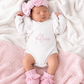 Newborn wearing personalized warm white Butterfly romper with petal pink bow and booties