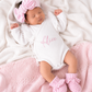 Newborn wearing personalized warm white Butterfly romper with petal pink bow and booties