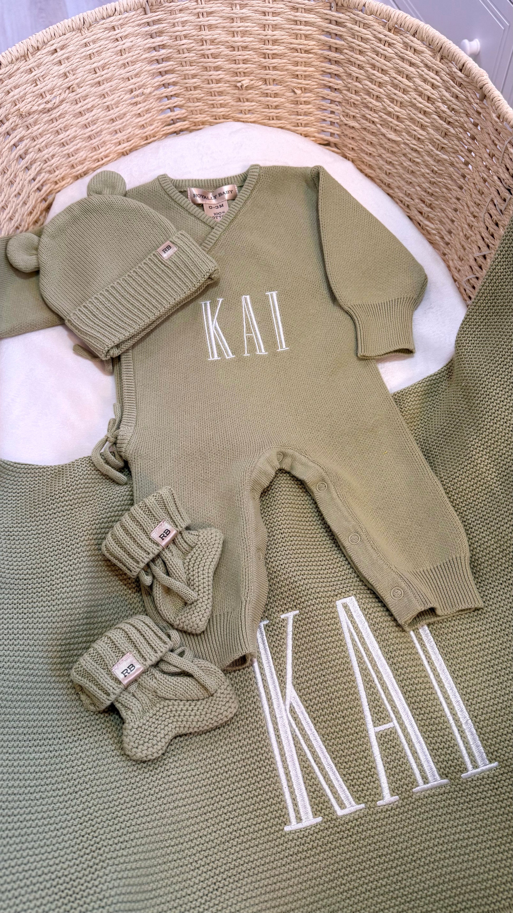 Personalized Soft Sage newborn romper set arranged with matching knit accessories