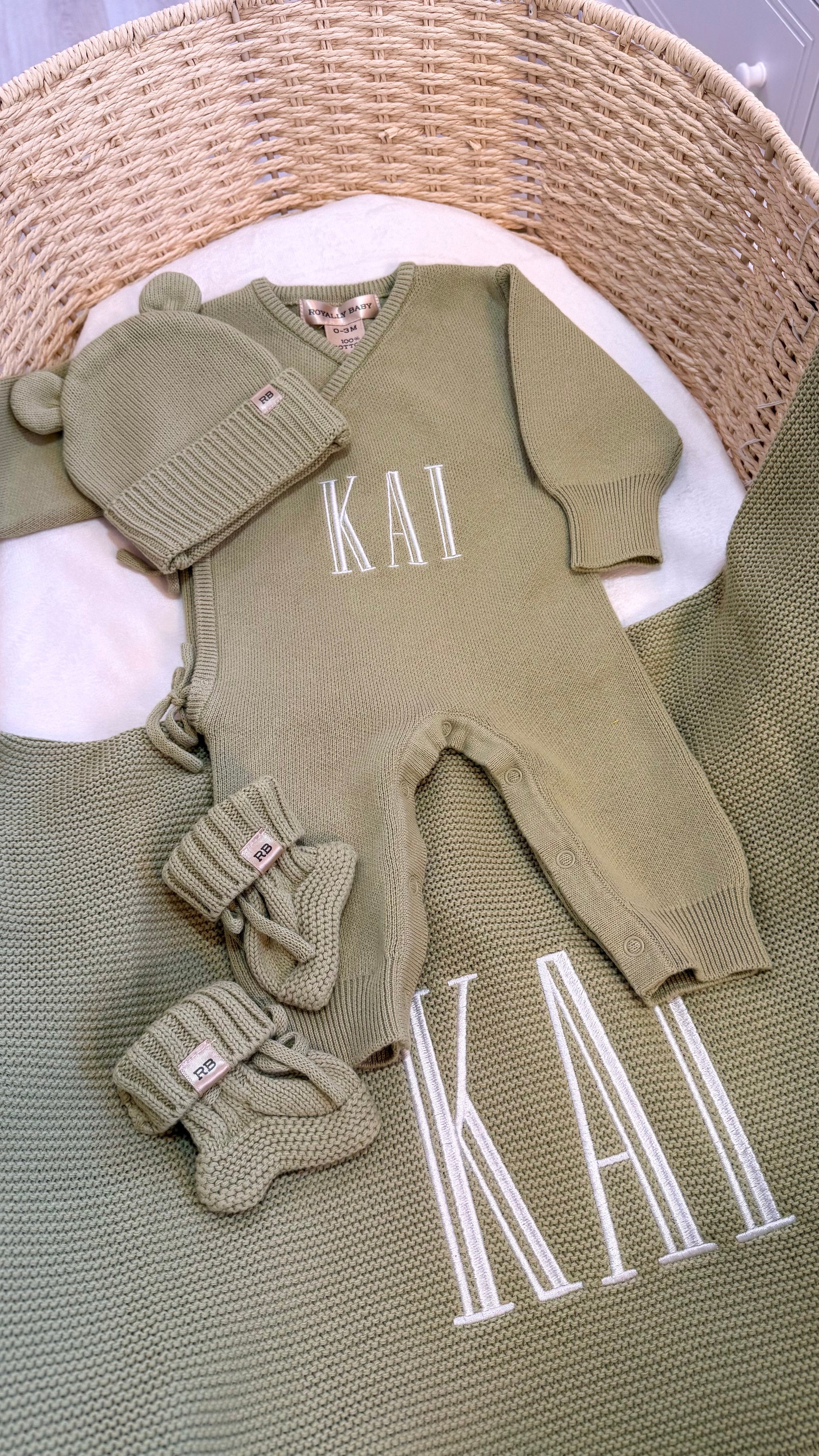 Personalized Soft Sage newborn romper set arranged with matching knit accessories