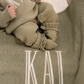 Baby wearing a personalized Soft Sage coming-home outfit with matching knit accessories