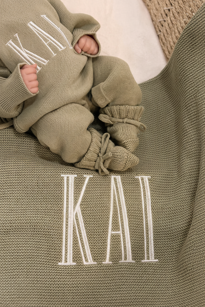 Baby wearing a personalized Soft Sage coming-home outfit with matching knit accessories