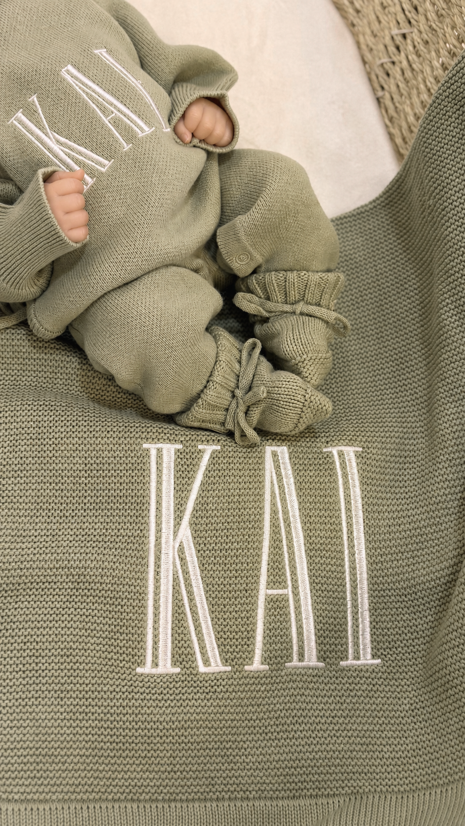 Baby wearing a personalized Soft Sage coming-home outfit with matching knit accessories