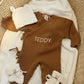 Personalized Teddy Brown Classic Knit Romper Set displayed with coordinating newborn accessories