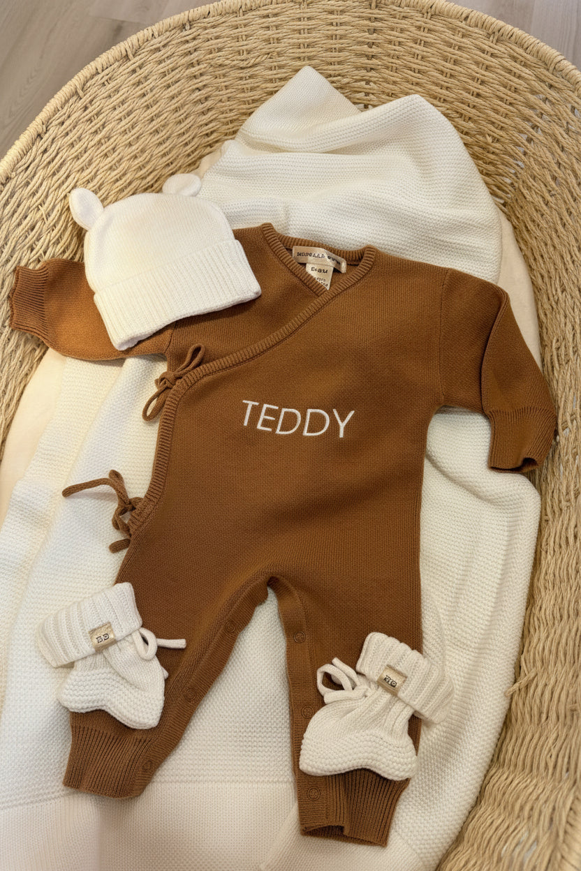 Personalized Teddy Brown Classic Knit Romper Set displayed with coordinating newborn accessories